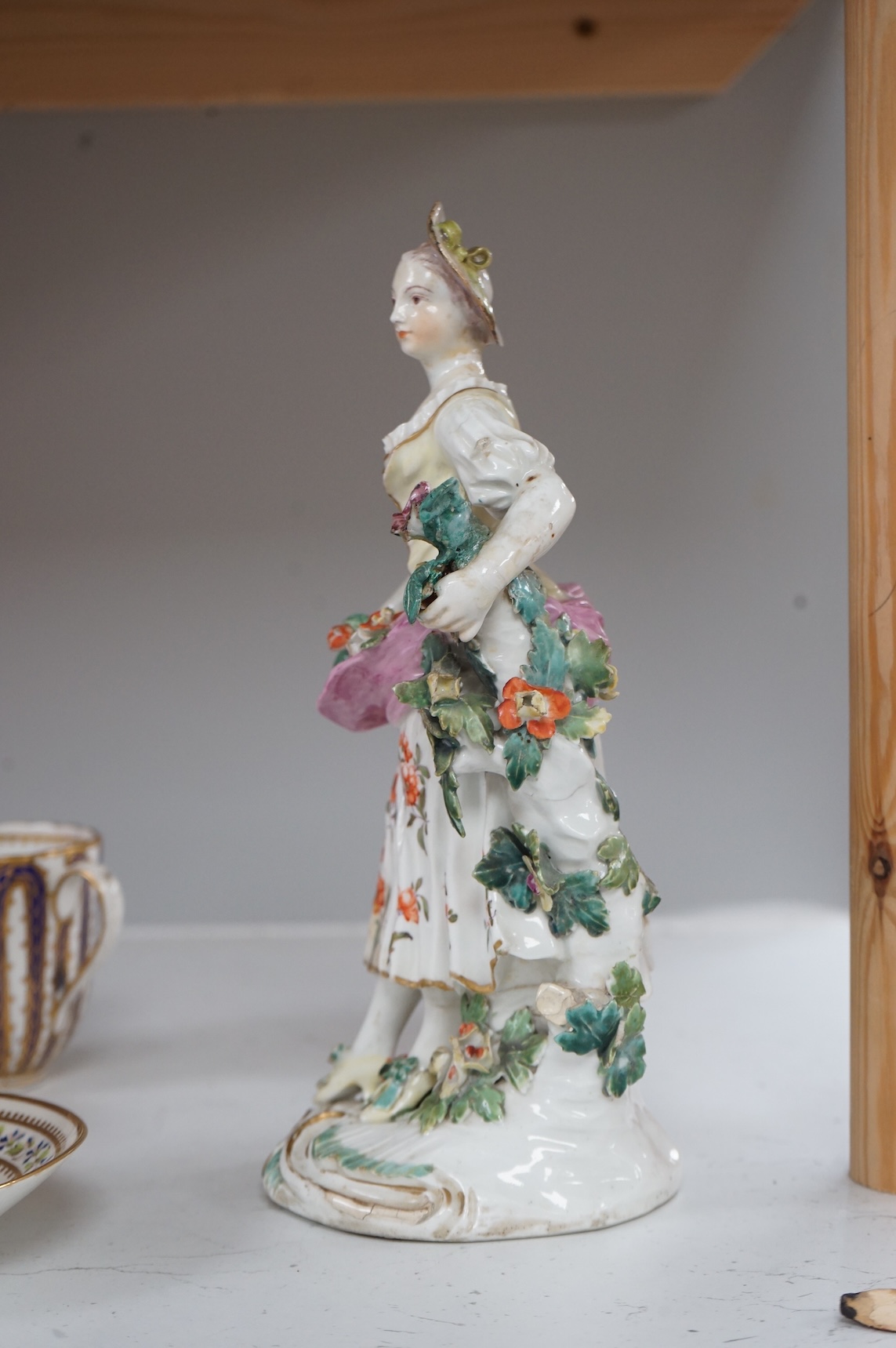 A Derby figure of a flower seller, c.1760, restored, 24cm high